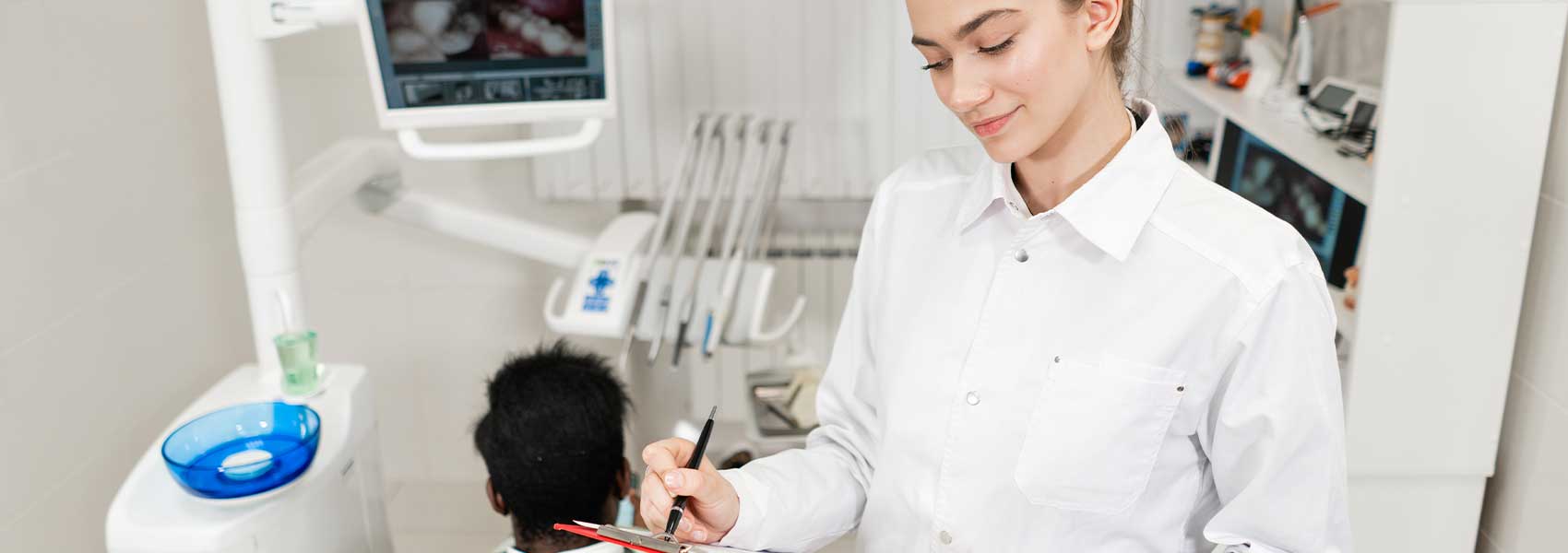 Lady dentist filling a new patient form